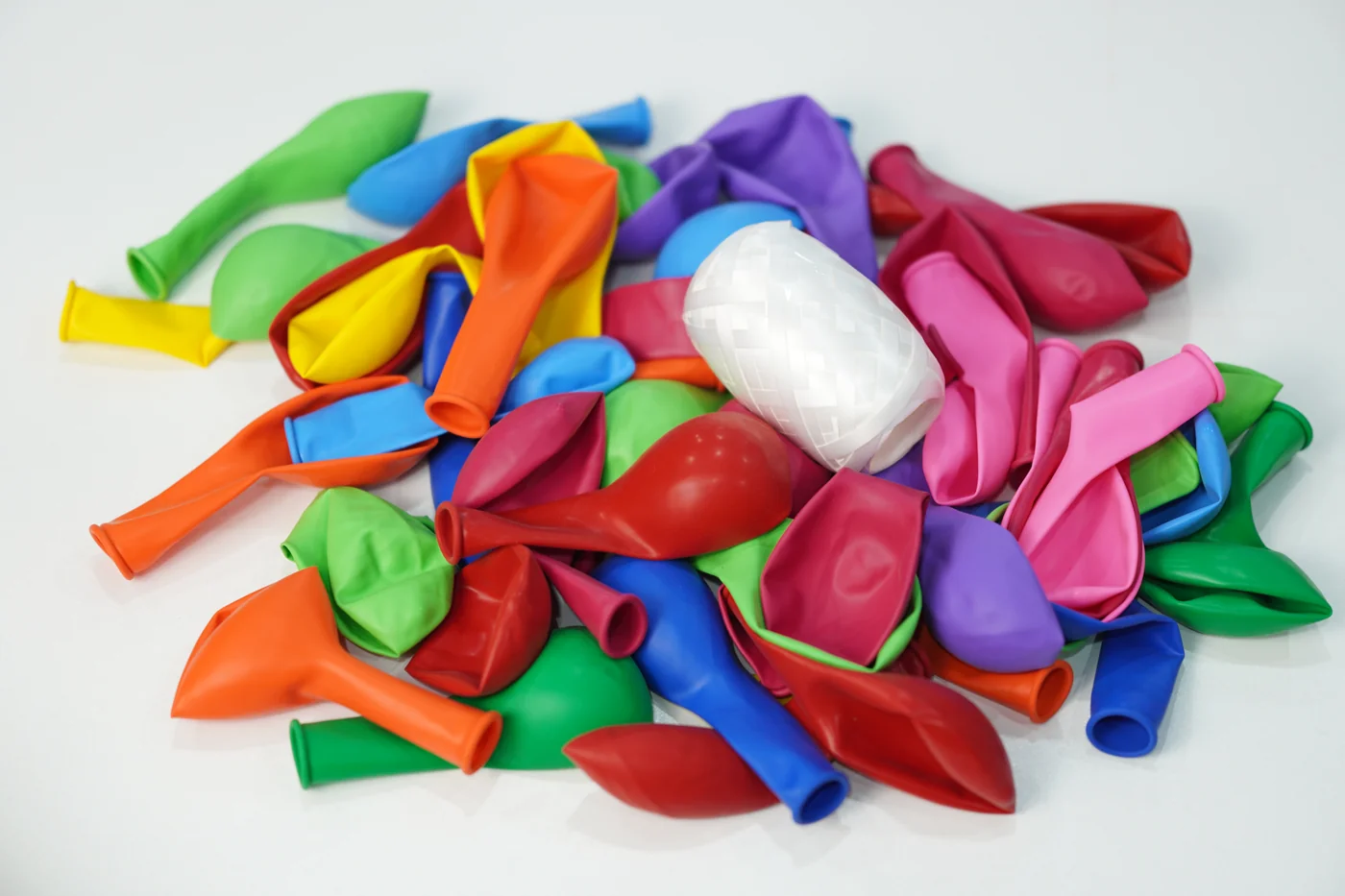Multicolored balloons and a spool of ribbon supplied with the helium kit